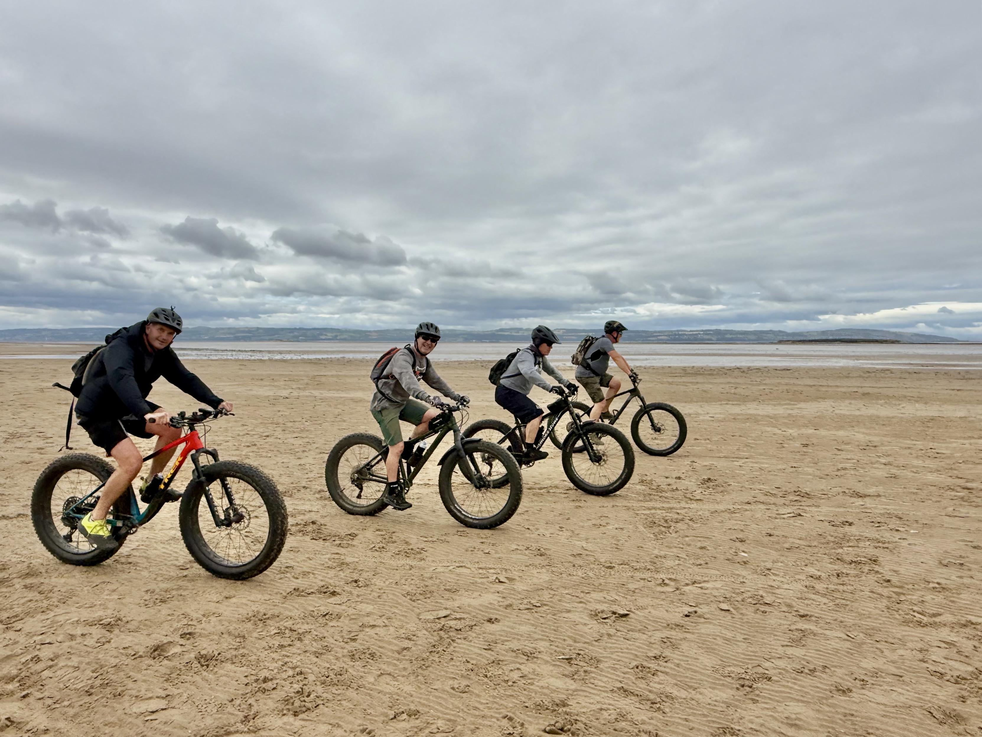 Four cyclists on a beach