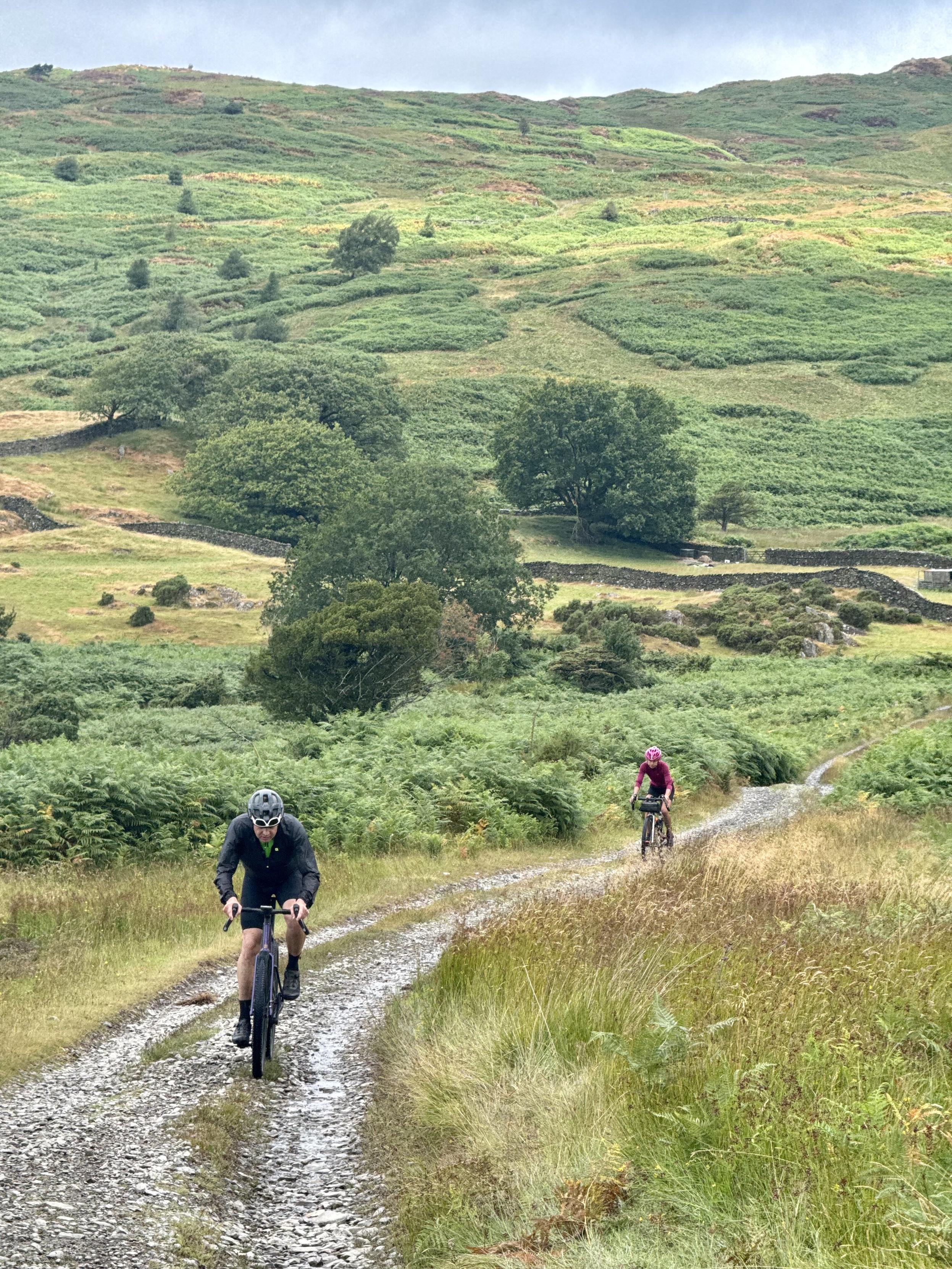 Cyclists riding a gravel track towards the camera