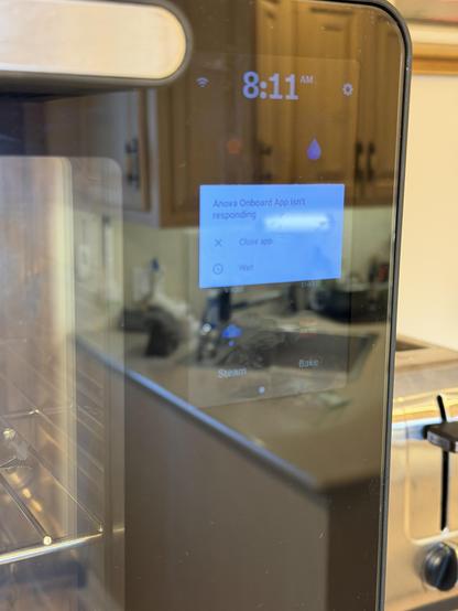 The front panel of a toaster oven with a phone-sized display showing an error message: “Anova Onboard App isn't responding. Close app or wait”