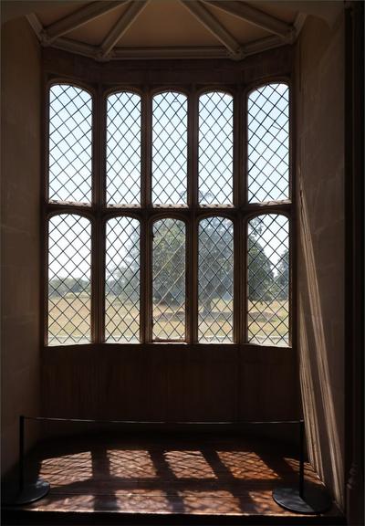 A diamond-pattern-glazed bay window. This is famous, as one of Fox Talbot's early photographs. Today in colour, and with a tree shown on the far side.