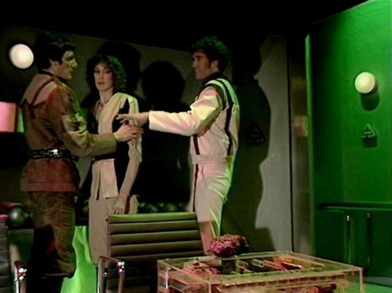 ChatGPT4 describes the image as: "The image depicts a scene from the television series "Blake's 7." It features three characters in a futuristic, sci-fi setting with a greenish tint. The room is equipped with a modern chair and a transparent table. The characters appear to be having a tense interaction, suggesting a dramatic moment in the show. The series is known for its sleek, futuristic design and complex character dynamics."

Blakes7Bot, version 3.7.34.