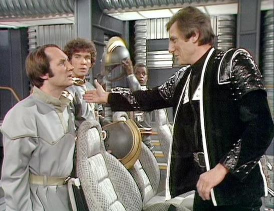 Claude Sonnet 4.0 describes the image as: "This scene takes place aboard the Liberator, the main spacecraft used by the rebel crew. The setting appears to be the ship's flight deck or a similar interior area, characterized by the distinctive white and metallic design elements typical of the series' futuristic aesthetic.

In the image, we can see crew members in their characteristic costumes - one person wearing the familiar light-colored leather outfit, while another is dressed in the black lea…