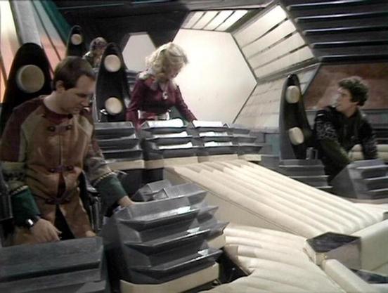 Claude Sonnet 4.0 describes the image as: "This appears to be a scene from inside a spacecraft, showing the futuristic interior with curved walls, metallic surfaces, and distinctive hexagonal lighting panels. The setting has the characteristic high-tech aesthetic of the series, with angular architectural elements and a sterile, functional design typical of the spaceship environments. The scene shows what appears to be crew members in their typical attire - practical, utilitarian clothing suitab…