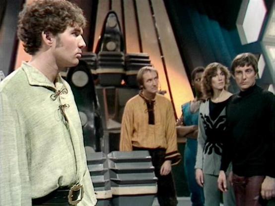 Claude Sonnet 4.0 describes the image as: "This appears to be a scene set aboard a spacecraft, featuring the characteristic futuristic interior design with metallic surfaces and geometric panels. The setting shows what looks like a control room or bridge area with technological equipment visible in the background.

In the foreground, one character wears a distinctive light-colored outfit with decorative fastenings or toggles. In the background, three other characters are positioned together - o…