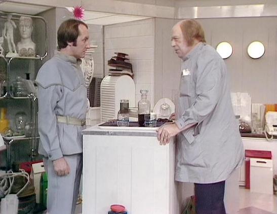 Claude 3.7 describes the image as: "This image shows a scene set in what appears to be a futuristic medical or laboratory facility with a clean, white interior design. Two people in gray uniform-like clothing are engaged in conversation across a white counter or examination table. One person on the left has a distinctive pink decoration or antenna on their head, while the person on the right has a more authoritative stance.

The clinical setting includes glass shelving with medical equipment, b…