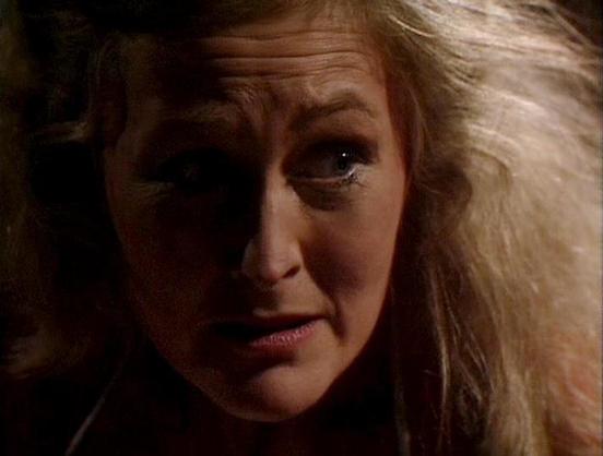Claude 3.7 describes the image as: "This image appears to be a close-up shot from a dramatic scene in a television production. The lighting is dim and atmospheric, creating shadows across the person's face, which gives the scene an intense, possibly tense mood. The person has wavy blonde hair and appears to be in an emotional state, with a concerned or distressed expression. 

The dark background suggests this may be from a scene set in a poorly lit interior space, perhaps during a confrontatio…