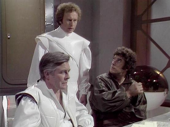 Claude Sonnet 4.0 describes the image as: "This appears to be a scene set in a futuristic medical or scientific facility. The setting features clean, sterile white and metallic surfaces typical of advanced spacecraft or research stations. Three figures are present in the scene - one seated in white medical or scientific attire in the foreground, another standing behind in similar white garments, and a third person positioned to the right wearing darker clothing. The environment suggests this co…