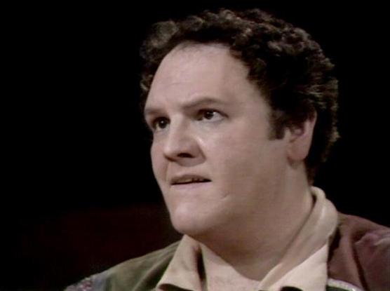 Claude Sonnet 4.0 describes the image as: "I can see this appears to be from a science fiction television production, likely from the late 1970s or early 1980s based on the image quality and styling. The scene shows someone in what appears to be casual clothing against a dark background, suggesting this might be from a dramatic or serious moment in the episode. The lighting and composition are typical of British television productions from that era. Without being able to identify the specific i…