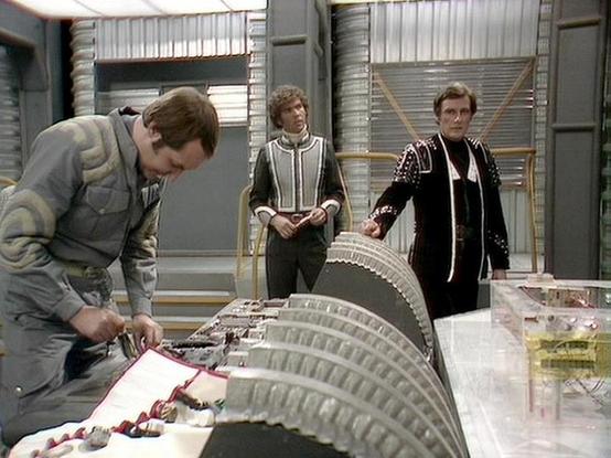 Claude Sonnet 4.0 describes the image as: "This scene appears to be set in a futuristic control room or technical facility, characterized by metallic walls and advanced-looking equipment. Three characters are present, with one person in work clothing leaning over what appears to be a large curved console or technical apparatus, manipulating some kind of control surface or readout. Two other figures stand in the background, dressed in more formal attire with distinctive trim details typical of t…