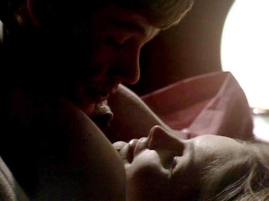 Claude 3.7 describes the image as: "This image appears to be from a dimly lit, intimate scene in a television drama. The lighting is low-key and atmospheric, creating a moody, emotional setting. The composition shows a close-up of two people in what seems to be a tender or emotional moment. 

The image has a vintage quality to it, suggesting it's from an older production, likely from the late 1970s or early 1980s based on the filming style and visual aesthetic. The soft lighting highlights the …