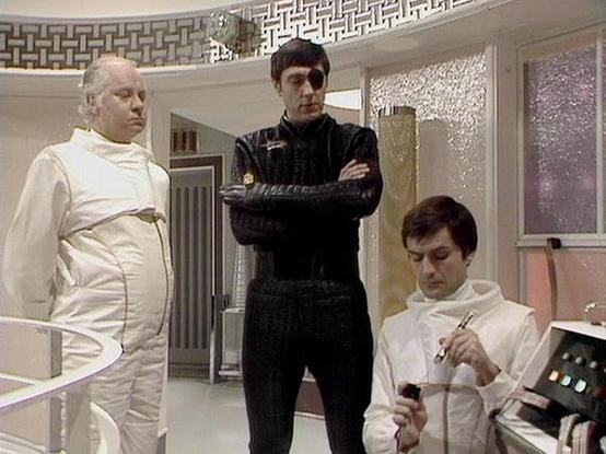 Claude Sonnet 4.0 describes the image as: "This appears to be a scene set in a futuristic medical facility or laboratory. The setting features clean, white sterile walls with geometric patterns and modern-looking control panels. Three figures are present in the scene - two wearing white medical or scientific garments that suggest they are doctors or technicians, while one person in the center wears a dark uniform, possibly indicating a different role or authority. The sterile, high-tech environ…