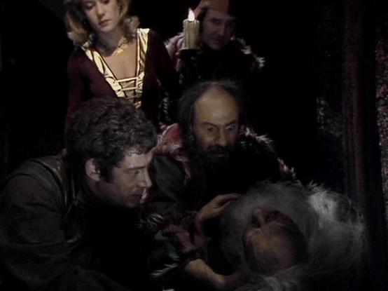 Claude Sonnet 3.7 describes the image as: "The image shows a dark, dramatic scene that appears to be from a period drama or theatrical production. Several people are gathered around what seems to be someone who is lying down - possibly ill or injured. The setting has a historical atmosphere with period costumes, including a woman in a burgundy dress with gold detailing in the background, who is holding a candle that provides much of the scene's lighting.

The figures are leaning in with concern…