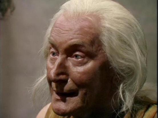 Claude Sonnet 4.6 describes the image as: "The image appears to be a close-up shot from the classic BBC Television series **Blake's 7**, likely filmed in the late 1970s or early 1980s. The production quality, lighting, and video format are consistent with BBC television productions of that era.

The scene shows an elderly male actor with long white hair swept back from his face. He has a weathered, aged appearance with deep-set blue eyes and pronounced facial features. He appears to be wearing …