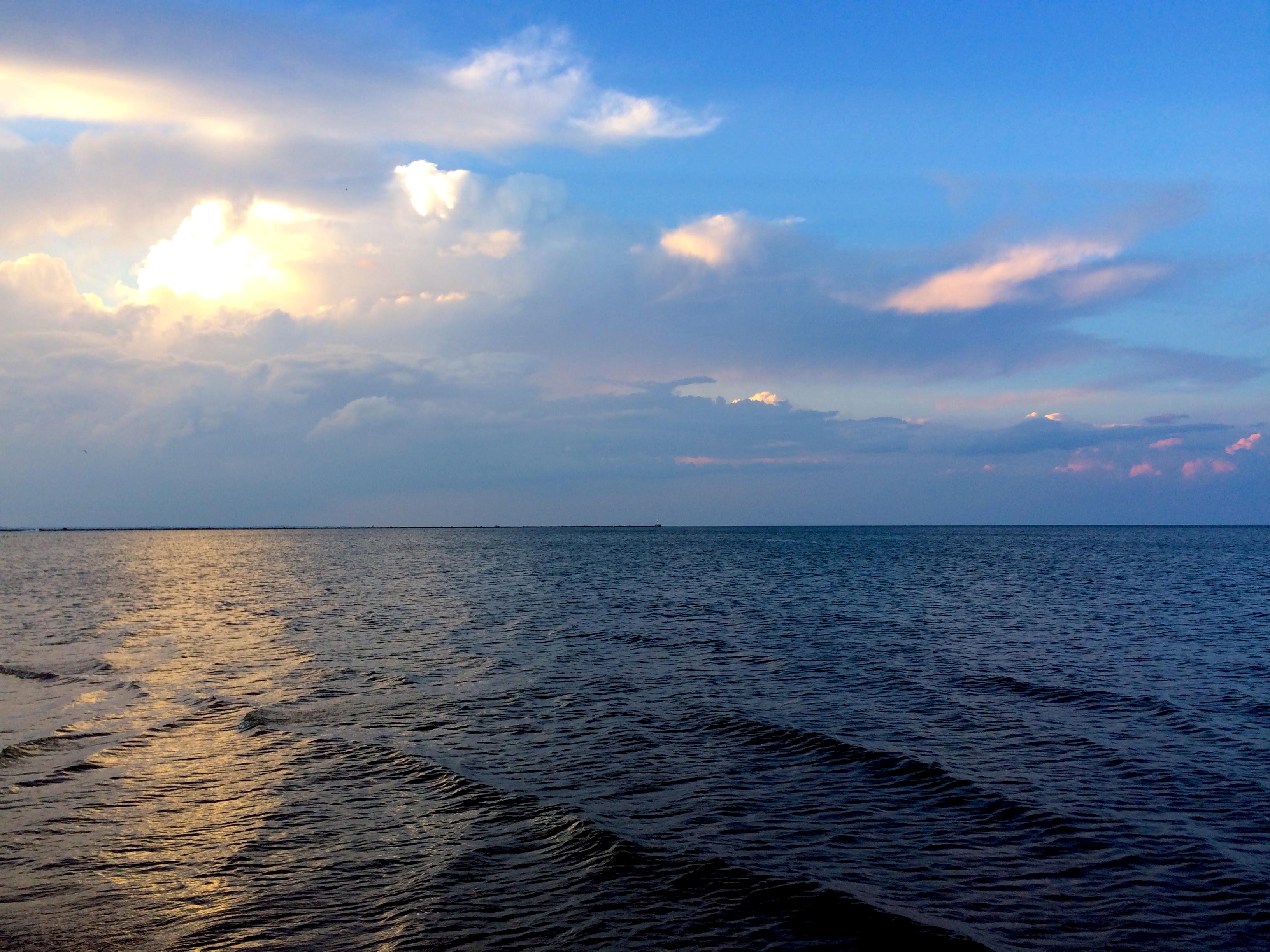 Background: Blue sky with thick gray and white cloud layers close to sunset casting a yellow glow and some pink glow on some clouds...
Middleground: Thin layer of land in the distance...
Foreground: Lake Erie water darkened by sunset with some minor waves...

Created: 8/11/2017 8:18 PM
Aperture: ƒ∕2.2
Exposure: 1∕184 s
ISO: 32
Focal Length: 4.15 mm