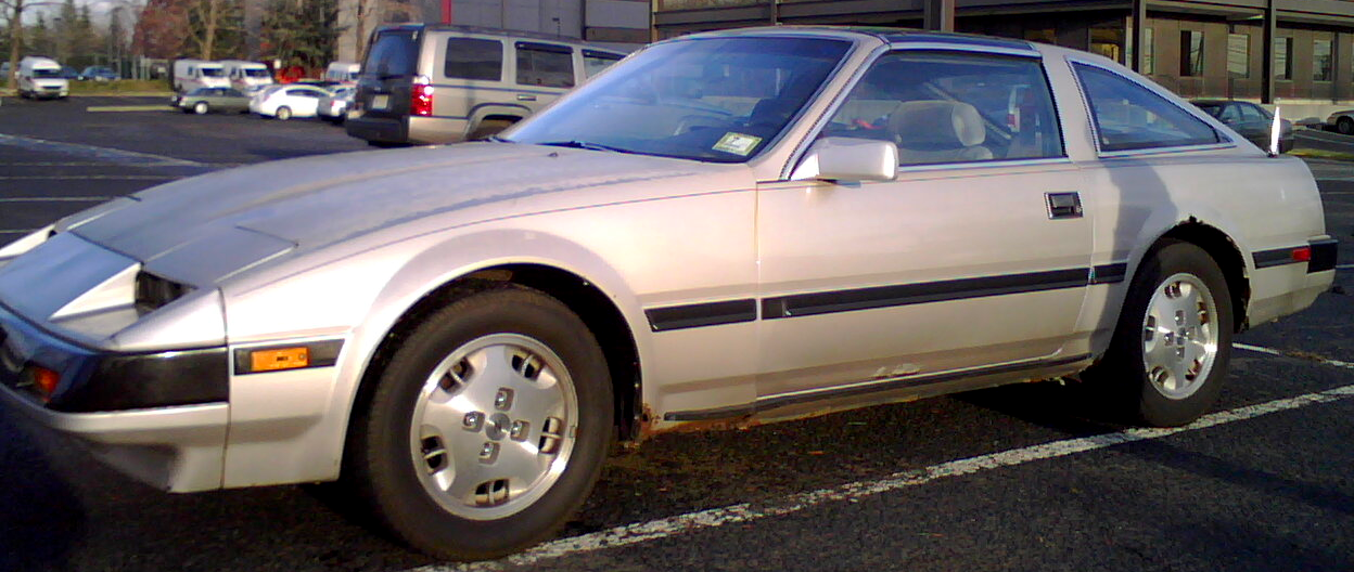 Background: Various random buildings ...
Middleground: Various parked cars in a parking lot...
Foreground: 1985 silver gray 300ZX sports car with black trim and rust forming behind front tire and above back tire... 

Created: 12/05/2008 3:11 PM
Aperture: ƒ∕???
Exposure: 1∕?? s
ISO: ??
Focal Length: ??? mm
Camera: BlackBerry 8100