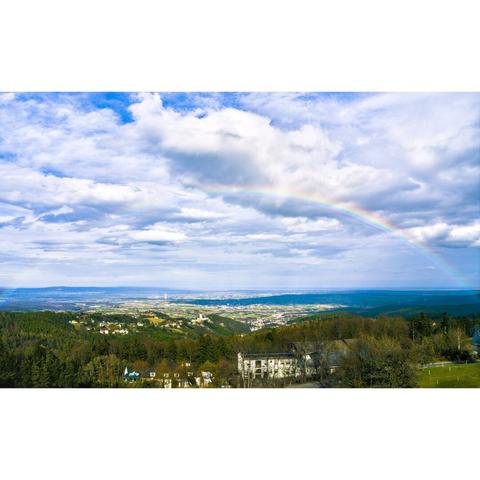 View of forchtenstein and mattersburg from the viewpoint rosalienkapelle with a rainbow, austria