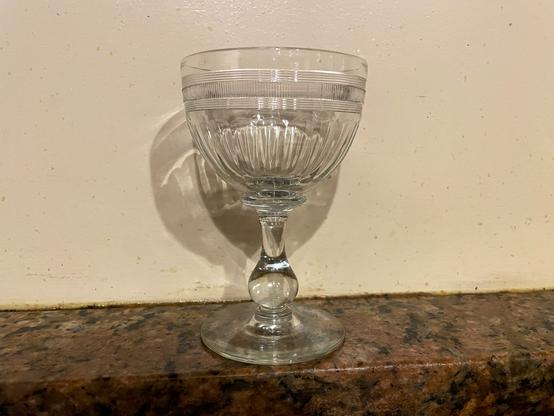 Slightly ornate wine glass on a counter.