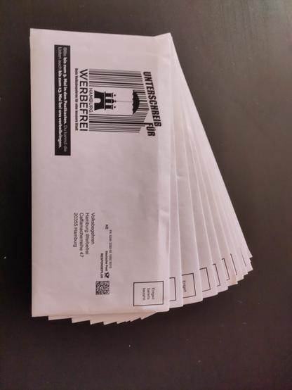 Ein Stapel Umschläge mit "Unterschreib für Hamburg Werbefrei - bis zum 9. Mai in den Briefkasten (Porto bereits bezahlt)"