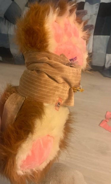 A photo of the underside of fursuit footpaws/shoepaws. The underside is light brown fur, the rest of the paw is darker brown, and there are pink pawpads visible, as well as gray claws made of minky fabric.