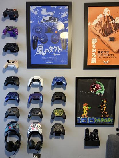 16 wall mounted controllers of various kinds and colors. 

We have:

Vader 3 Pro
Apex 4
Vader 4 Pro
King King 3 Max
Wolverine V3 Pro
Xbox Series X, purple/blue
Design Lab Elite Series 2, grey/orange
Design lab Xbox Series X, blue camo
PS5, white
PS5, purple/blue
Xbox 20th Anniversary, translucent black/green
Design lab Xbox Series X, white camo
ZD O+, blue
ZD O+, black
Elite Series 2, Halo edition
And finally, another Vader 4 Pro