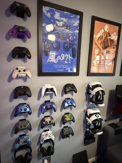 16 wall mounted controllers of various kinds and colors. 

We have:

Vader 3 Pro
Apex 4
Vader 4 Pro
King King 3 Max
Wolverine V3 Pro
Xbox Series X, purple/blue
Design Lab Elite Series 2, grey/orange
Design lab Xbox Series X, blue camo
PS5, white
PS5, purple/blue
Xbox 20th Anniversary, translucent black/green
Design lab Xbox Series X, white camo
ZD O+, blue
ZD O+, black
Elite Series 2, Halo edition
And finally, another Vader 4 Pro