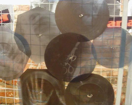 Zu Schallplatten geschnittene Röntgenaufnahmen hängen an einem Gitter.