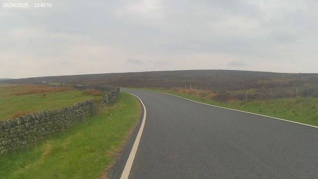 A cyclist view of a open road crossing moorland