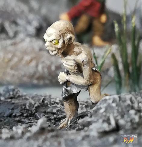 Front view of Golum miniature with Bilbo in the distance.