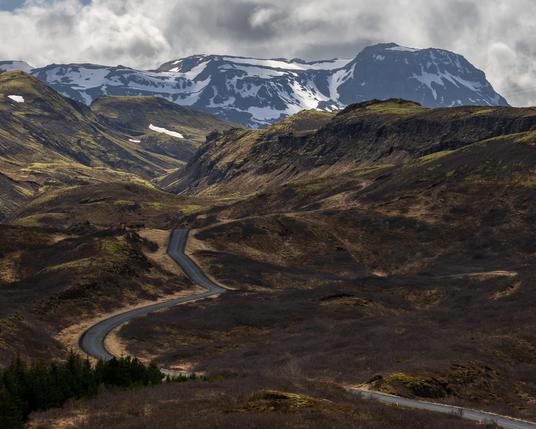 A picture of the mountain Hengill. A road leads the eye from the bottom right into the middle of the picture.