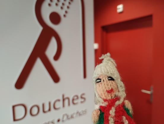 Dirty, dirty puppet standing in front of the shower sign in Toulouse Matabiau.
