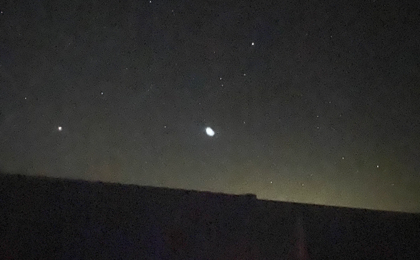 A bright blob of white light appears against the night sky.