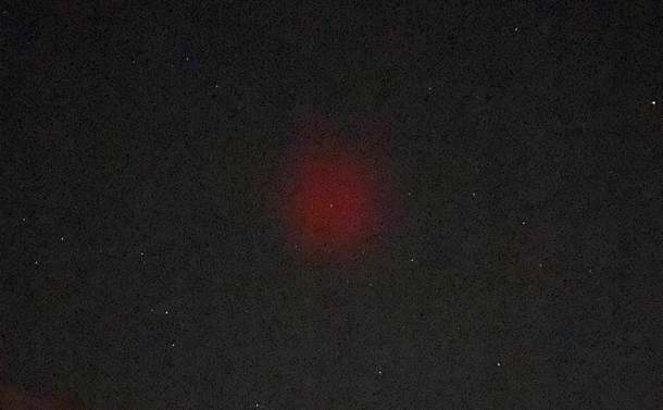 A round reddish glow appears against the night sky.