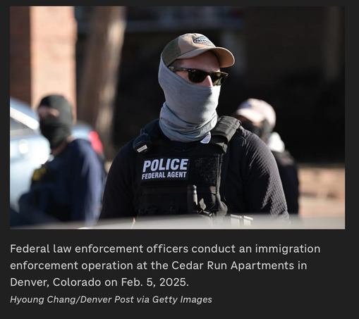 Photograph of an alleged officer of the law outfitted in military-style tactical gear. He or she is wearing a ball-cap, sunglasses, and a gaiter that conceals almost the entire face and neck. Similarly, outfitted officers appear in the background. The cut line reads, “Federal law enforcement officers conduct an immigration
enforcement operation at the Cedar Run Apartments in
Denver, Colorado on Feb. 5, 2025.
Hyoung Chang/Denver Post via Getty Images”