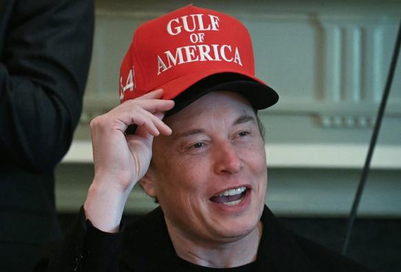 Elon Musk, wearing two hats, speaks during a cabinet meeting in the Cabinet Room of the White House in Washington, DC, on April 30, 2025.