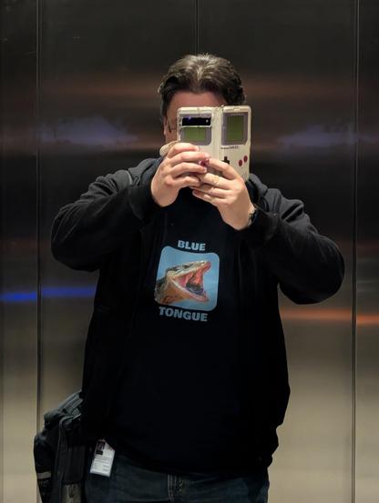 Photo of a person wearing a t-shirt with a photo of a blue tongue skink yawning printed on it.
