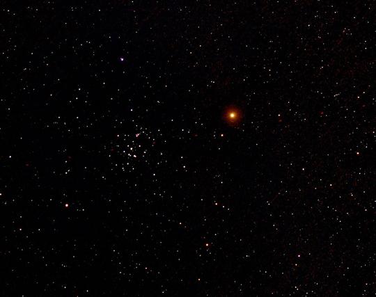 Red planet Mars at right of centre. The Beehive cluster of stars left of centre. Many other star dots on a dark background. All captured at 50mm focal length.