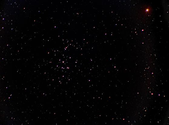 The Beehive cluster of stars at centre. Red planet Mars at upper right corner of the frame. Many other star dots on a dark background.