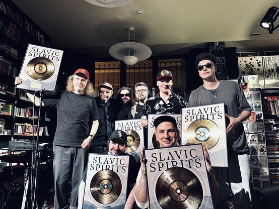 Gli Eabs, fotografati forse dentro al loro studio, mostrano felici e orgogliosi i quadri che contengono il disco d'oro con sopra scritto il titolo del disco, Slavic Spirits