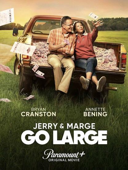 Bryan Cranston and Annette Bening sit in the back of a red pickup that is completely full of lottery tickets.
