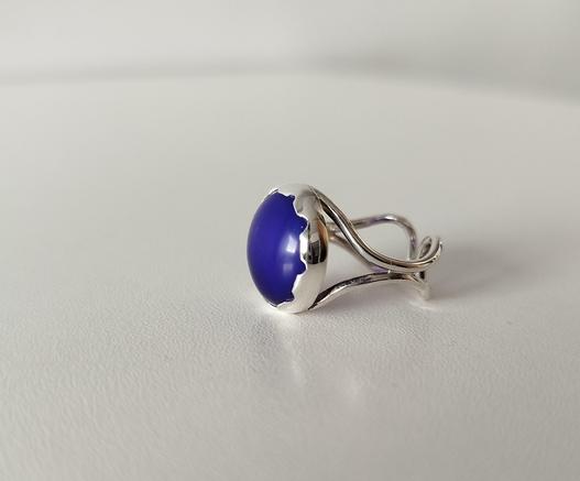 a silver open ring with a big blue stone