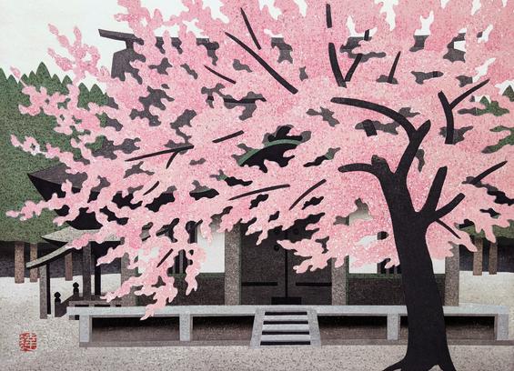 A tall, robust cherry tree stands in front of a Japanese temple, its branches loaded with pink blossoms. Ranks of green trees line up just beyond; above, the sky is milky and overcast.