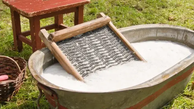 an old-fashioned washboard in a large tub of soapy water