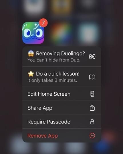 iOS screenshot of Duolingo app with dropdown options:

"Removing Duolingo? You can't hide from Duo."

"Do a quick lesson! It only takes 3 minutes."

"Edit Home Screen"

"Share App"

"Require Passcode"

"Remove App"