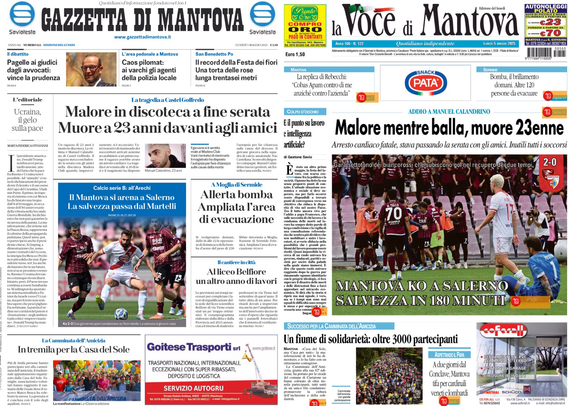 Due prime pagine di giornali sono visibili su uno schermo. A sinistra c'è la "Gazzetta di Mantova" e a destra "La Voce di Mantova". Entrambi i giornali riportano la notizia principale di un giovane di 23 anni che è morto in discoteca. La "Gazzetta di Mantova" ha il titolo "Malore in discoteca a fine serata. Muore a 23 anni davanti agli amici", mentre "La Voce di Mantova" titola "Malore mentre balla, muore 23enne". Entrambi i giornali presentano anche altre notizie e immagini, tra cui eventi sportivi e locali.  .