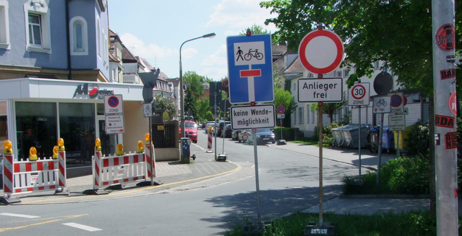 Schilderwald mit Widersprüchen:
Einmündung einer für Radverkehr gegen die Fahrtrichtung freigegebenen Einbahnstraße, in die aktuell auch Anlieger einfahren dürfen - Radfahrer aber nicht mehr ...