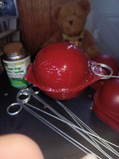 A red plastic sphere mounted in the the coiled wire holder and coated with sticky stuff.