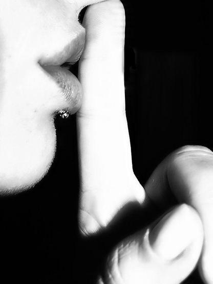comfortable with silence: black and white photograph of a close-up of a person putting their finger to their lips. Photo attribution: Flickr user ko_an