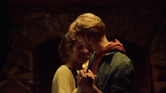 A young couple dancing and holding hands.