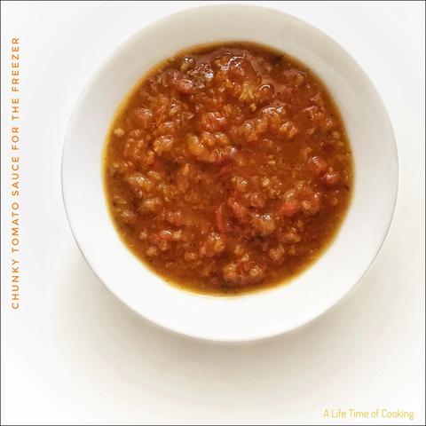 A bowl of red chunky tomato sauce.