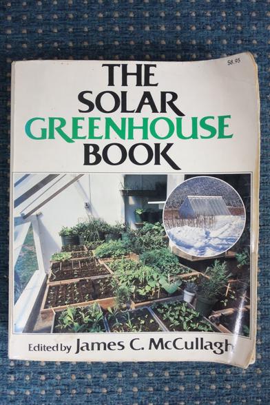 pic of the book 'THE SOLAR GREENHOUSE', paperback, white, title in big letters, black, GREENHOUSE in green with a colour photo showing an solar greenhouse in a circle and the interior of a greenhouse with a lot of young plants in trays and pots.
on the bottom it says "Edited by James C. McCullagh"